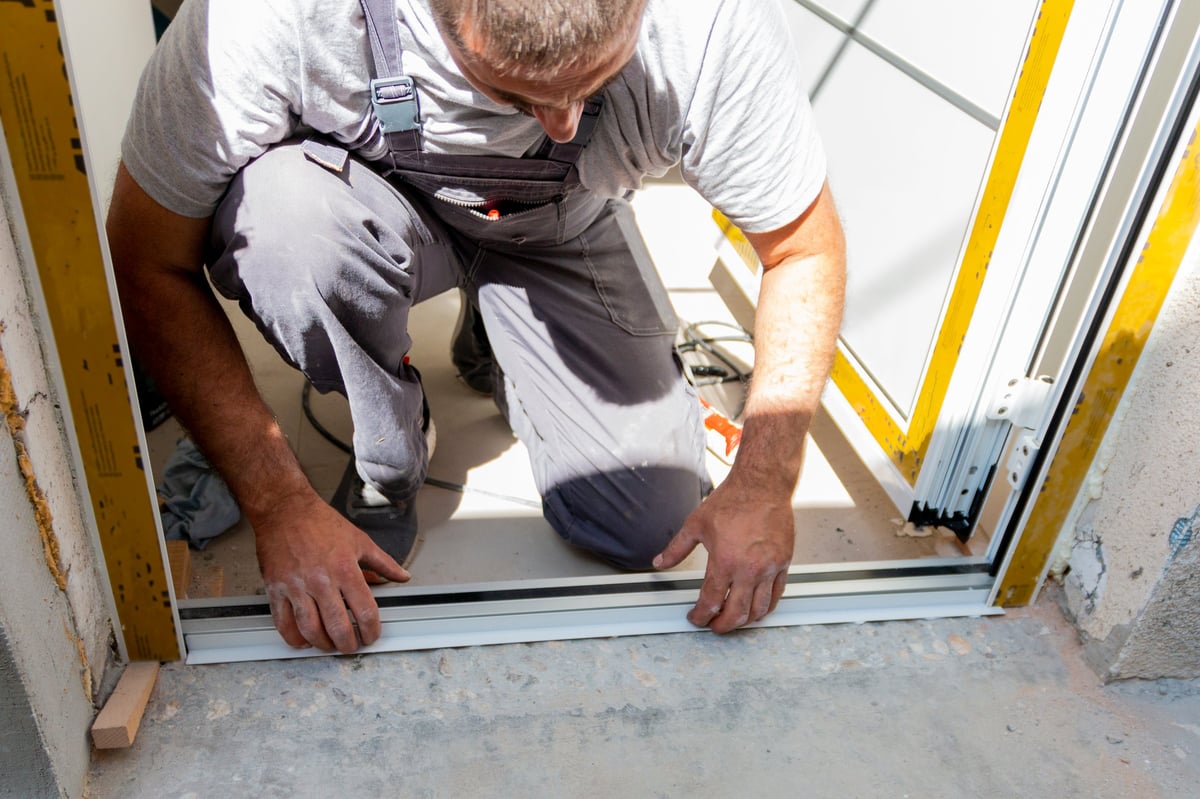 Craftsman installing a new wood entry door on a Southwestern Pennsylvania home