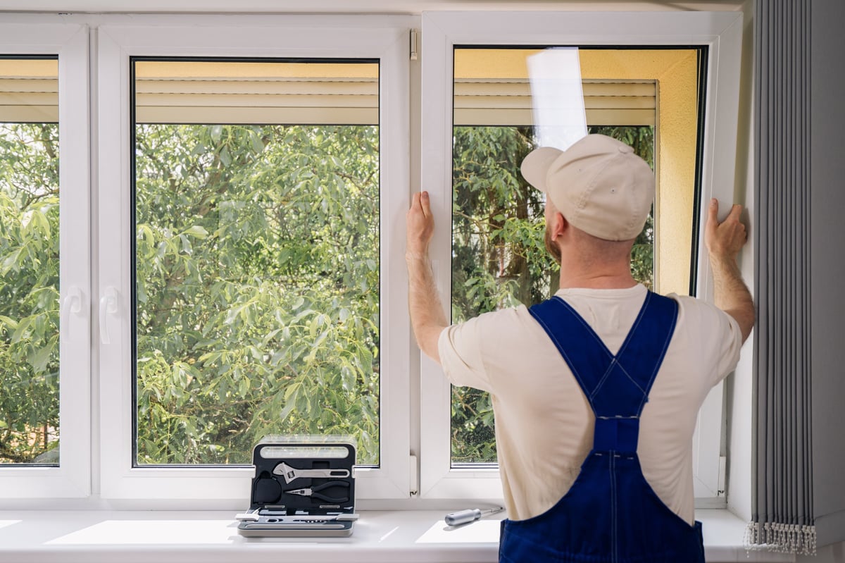 Installer fitting a new window frame in a residential home