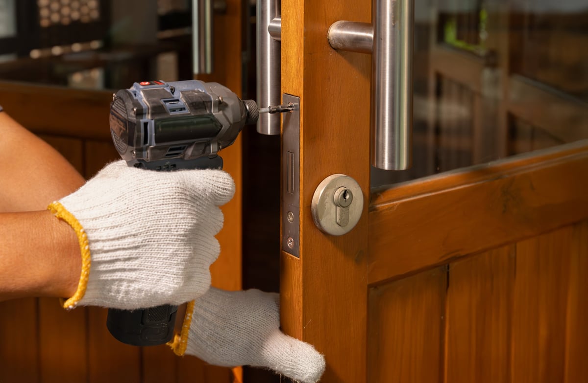 Technician fitting the hardware on a storm door